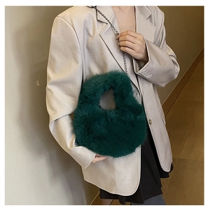 Borsa a mano in pelliccia sintetica verde scuro con catena d'argento su modella