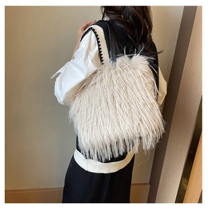 Vue détaillée du sac fourre-tout en fausse fourrure blanc crème avec bandoulière en cuir noir