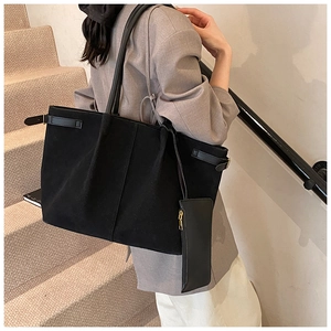 Detail van minimalistische zwarte matte shopper met gouden gesp en extra tasje