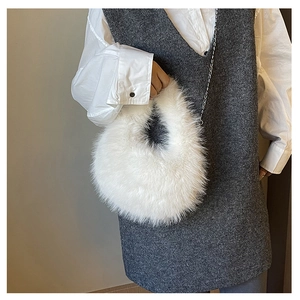 Borsa a tracolla minimalista in ecopelliccia bianca con catena d'argento su un modello