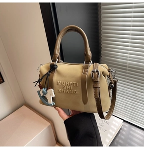 Detail of khaki leather Boston bag with embossed text and horse charm accessory