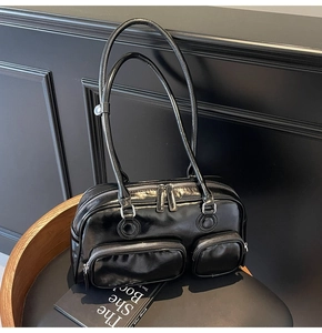 Close-up of black glossy bowling bag featuring dual front pockets and silver zippers