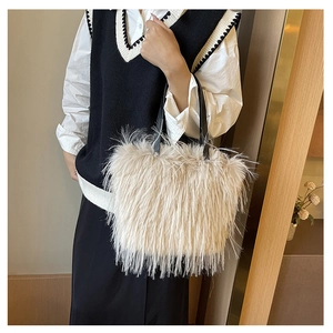 Détail d'un sac cabas en fausse fourrure blanc crème avec des anses noires au porté