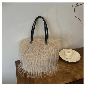 Détail du sac cabas en plumes synthétiques avec poignées noires sur table en bois