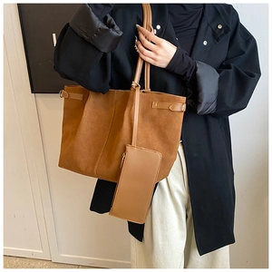 Detailed view of brown suede tote bag with matching zipper pouch and slender handles