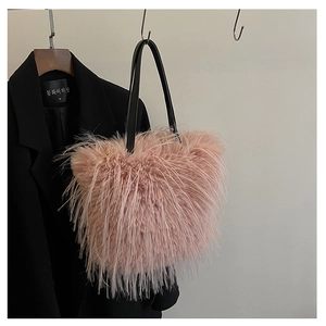 Détail du sac cabas en plumes roses avec texture duveteuse et poignées en cuir noir