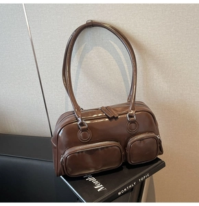 Close-up of glossy brown bowling bag featuring double front zip pockets on books