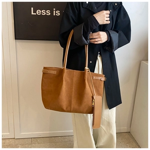 Détail du sac cabas en daim marron avec couture verticale et mini pochette amovible