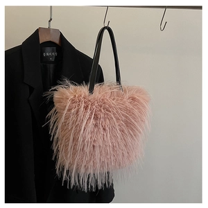 Détail du sac cabas en fausse fourrure rose avec de fines anses noires en cuir souple