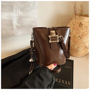 Détail du sac seau marron rétro avec boucle métallique et pendentif en corde tressée