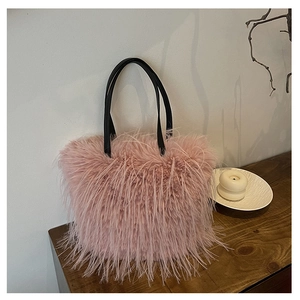 Détail du sac cabas rose en peluche avec anses noires sur une table en bois décorée