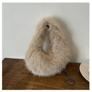 Dettaglio della borsa beige in peluche con pelliccia sintetica e catena in metallo