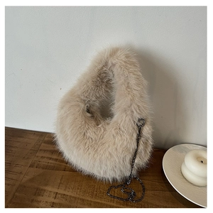 Dettaglio borsa di peluche beige con texture in ecopelliccia e catena in metallo