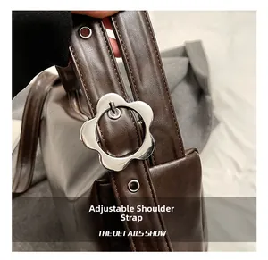 Close-up of adjustable leather shoulder strap with a silver flower-shaped metal buckle