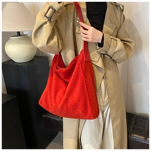 Detalle del bolso hobo de peluche rojo con correa de cuero ancha para otoño e invierno