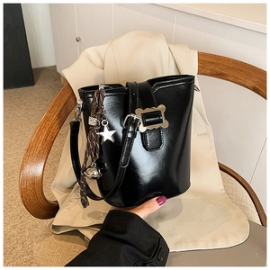 Détail du sac seau noir en similicuir avec boucle argentée et pendentif en étoile