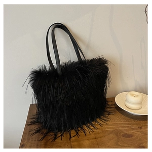 Détail du sac cabas en plumes noires avec anses en cuir pour un style d'hiver élégant