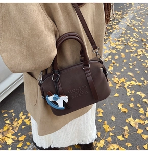 Vista esterna di una borsa Boston grande in pelle marrone con dettaglio ciondolo cavallo