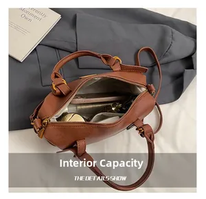 Internal capacity of brown leather Boston bag showing phone and cosmetics