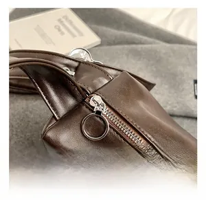 Close-up of premium dark brown leather tote bag with round silver metal zipper detail