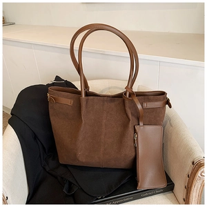 Gros plan d'un grand sac cabas en daim marron foncé avec une pochette rectangulaire assortie
