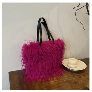 Détail d'un sac cabas en fausse fourrure rose rouge sur une table en bois rustique