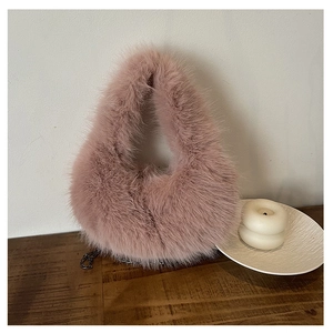 Dettaglio borsa in ecopelliccia rosa con tracolla a catena in metallo su legno