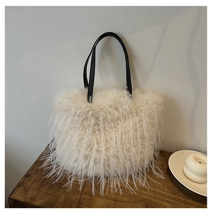 Détail d'un sac à main en peluche blanche avec poignées en cuir noir sur bois