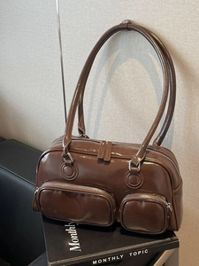 Deep brown bowling shoulder bag in vintage oil-wax leather with metal zip pockets