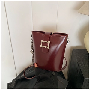 Détail du sac seau bordeaux avec boucle ondulée argentée et pendentif étoile chic