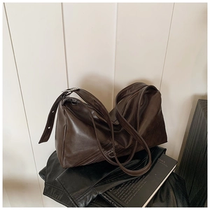 Detailed view of deep brown vintage shoulder bag with silver ring hardware and long strap