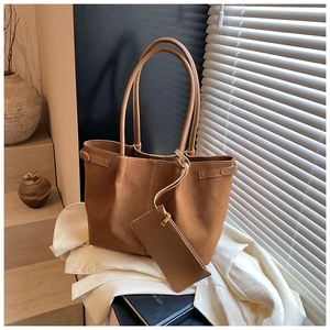 Detail of vintage brown suede tote bag with matching zippered pouch and side strap accents