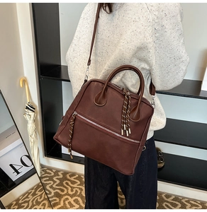Dettaglio di borsa vintage in pelle marrone con nodo intrecciato e tracolla regolabile