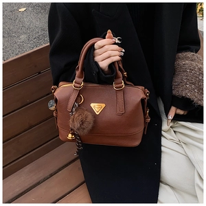 Deep brown PU leather Boston bag detail with plush fur ball and golden bell charm
