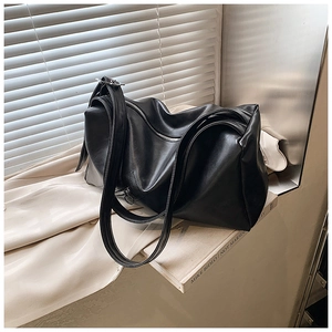 Close-up of a matte black leather tote bag with soft texture and metallic zipper detail