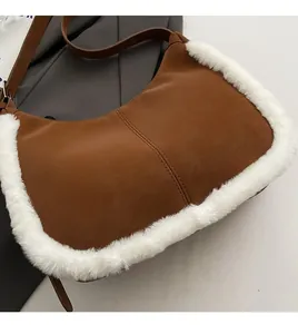 Detail of faux suede shoulder bag with plush shearling trim and brown leather strap