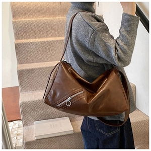 Brown vintage faux leather tote bag with side metal zipper shown on a model's shoulder