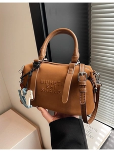 Vintage brown Boston satchel bag with stylish embossed text and horse charm accessory