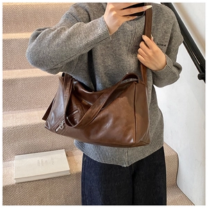 Close-up of the vintage brown crossbody pillow bag showing side zipper and leather texture
