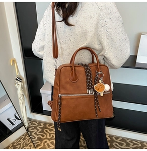 Cartella in pelle marrone con tirazip intrecciato e dettaglio ciondolo da baseball