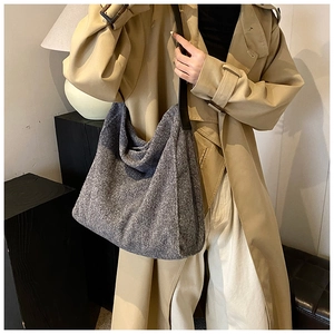 Bolso tote de lana gris oscuro con correas de cuero sobre una gabardina beige
