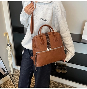 Borsa in pelle marrone con manici rotondi e dettaglio nappa con tracolla regolabile