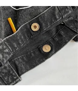 Detail of light gold magnetic snap buttons on premium black washed denim tote bag