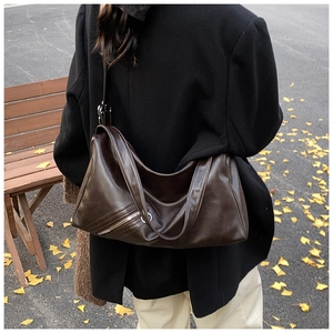 Detailed view of deep brown vintage hobo bag with zip pocket and metal ring on model