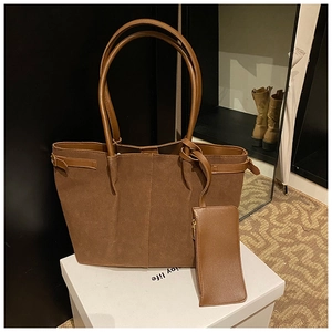 Détail du sac fourre-tout en cuir mat marron foncé avec pochette assortie sur boîte