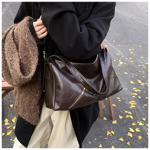 Detail of vintage brown leather pillow bag with stylish diagonal zipper in autumn setting