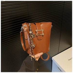 Détail du sac seau en cuir mat marron avec breloque étoile argentée et corde tressée