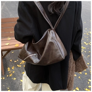 Detail view of large dark brown retro pillow bag with side zipper and metal ring charm