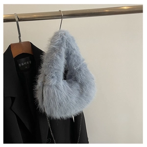 Dettaglio della borsa di peluche celeste con catena in metallo e morbida ecopelliccia