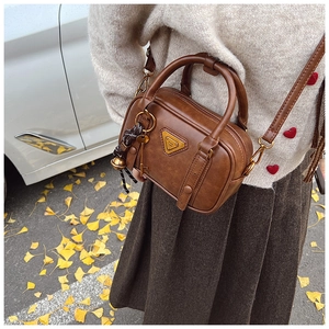 Vintage braune Boston Bag mit Metalldreieck vor herbstlichem Hintergrund im Freien gezeigt